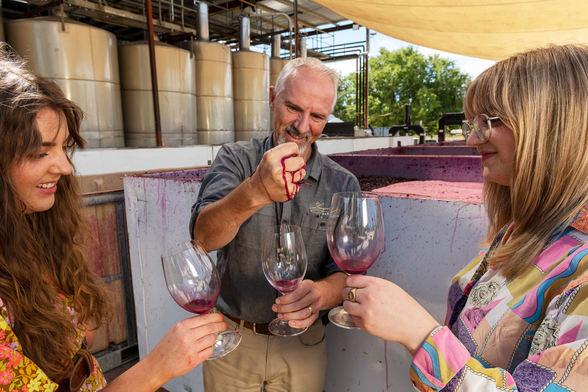man squeezing grapes on private wine tour